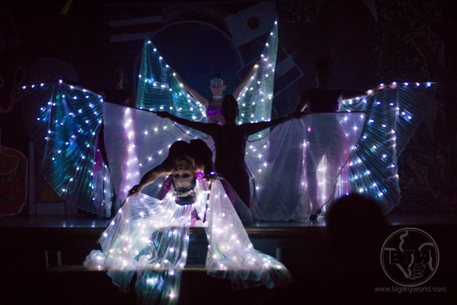 Three dancers posing with illuminated wings on a dark stage during a show at the Doubletree Resort in Puntarenas, Costa Rica | BIG tiny World Travel