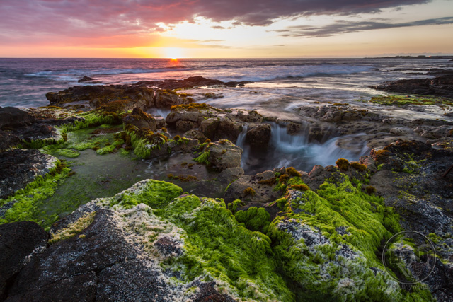 Sunset over a puka at the coast of the Big Island on Hawaii, just outside of Kona