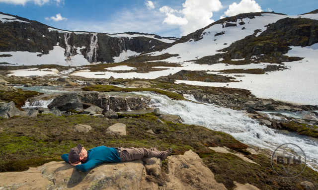 Aaron lounging in front of the creek and waterfalls | LotsaSmiles Photography