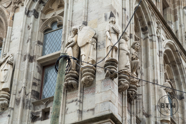 Statues carved into a building wall in Cologne, Germany